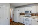 White kitchen with wood-look flooring, white cabinets and appliances at 271 Kings Walk, Douglasville, GA 30134