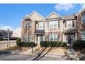 Tan and brick two-story townhome with front yard landscaping at 5473 Festival Ave, Fairburn, GA 30213