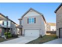 Two-story house with beige siding, attached garage, and a landscaped front yard at 2291 Elise Way, Hampton, GA 30228