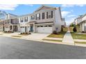 Two-story townhome with white and gray brick exterior, two-car garage, and landscaped front yard at 510 Cooper Ln, Woodstock, GA 30189
