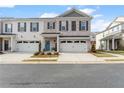 Two-story townhome with white and gray brick exterior, two-car garage, and landscaped front yard at 510 Cooper Ln, Woodstock, GA 30189