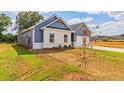 Side view of a two-toned house with landscaping and a partially visible driveway at 231 Orwell Dr, Social Circle, GA 30025
