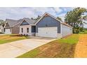House exterior showcasing a two-car garage and landscaping at 231 Orwell Dr, Social Circle, GA 30025
