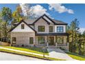 Two-story brick home with white accents, dark windows, and a welcoming front porch at 5610 Bent Grass Way, Douglasville, GA 30135