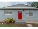 Front entrance with a red door and gray brick facade at 6103 Oakwood Sw Cir, Covington, GA 30014