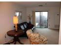 Living room with leather couch, floral chair, and balcony access at 300 Johnson Ferry Rd # B802, Atlanta, GA 30328