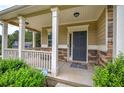 Covered porch with white columns, stone base, and a dark gray front door at 138 Gorham Gates Dr, Hiram, GA 30141