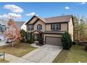 Two-story house with brown and beige siding, a large garage, and landscaping at 904 Berry Ct, Canton, GA 30114