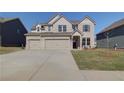 Two story home with three car garage and light brick exterior at 2296 Cadenza Cir, Dacula, GA 30019