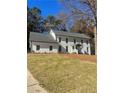Beautiful white two-story house with a gray roof and manicured lawn at 5085 Shadow Glen Ct, Dunwoody, GA 30338