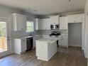 Modern kitchen featuring white cabinets, island, and stainless steel appliances at 5439 Beaver Lake Dr, Powder Springs, GA 30127