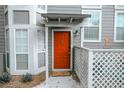 Inviting orange front door with a gray building exterior and a white lattice fence at 1403 Riverview Se Dr, Marietta, GA 30067