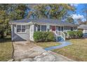 Gray brick ranch house with a red door and well-maintained landscaping at 2415 Plantation Dr, Atlanta, GA 30344