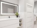 Modern bathroom featuring a large backlit mirror, white vanity, and rolled-up towels at 1600 Cherry Hill Sw Ct, Conyers, GA 30094