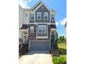 Three-story townhome with gray siding, stone accents, and a two-car garage at 2611 Hedgeway Cir, Kennesaw, GA 30144