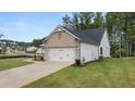 White two-car garage with brick facade and landscaping at 305 Sobeck Way, Canton, GA 30115