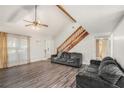 Living room with wood-beamed ceilings, dark couches, a stone fireplace, and staircase at 850 Kenwood Ln, Jonesboro, GA 30238