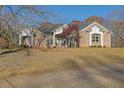 Brick house with a large front yard, driveway and mature trees in the background at 6740 Mountain Lake Ln, Cumming, GA 30028