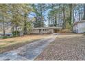 Ranch home with a paved driveway and wooded backyard at 1374 Margarette Dr, Decatur, GA 30035