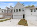 Two-story townhome with gray and white brick exterior, two-car garage, and landscaped front yard at 687 Sunstone Ln, Lawrenceville, GA 30043