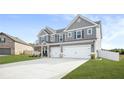 Two story gray house with white accents, three car garage, and front porch at 1049 Bodega Loop, Locust Grove, GA 30248