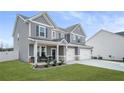 Two story gray house with white accents, three car garage, and front porch at 1049 Bodega Loop, Locust Grove, GA 30248