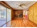 Living room with hardwood floors, brick fireplace, ceiling fan, and access to a sunroom at 11790 Brown Bridge Rd, Covington, GA 30016