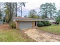 Brick house with a grey garage door and a yard with autumn leaves at 2348 Clifton Springs Mnr, Decatur, GA 30034