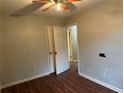Bedroom with wood-look floors, ceiling fan, and open door to another room at 125 Belmont Farms Dr, Ellenwood, GA 30294