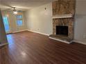 Living room with wood-look floors, stone fireplace, and access to the backyard at 125 Belmont Farms Dr, Ellenwood, GA 30294