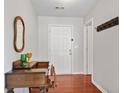 Bright entryway with hardwood floors, a wooden desk, and coat rack at 3822 Holliwell Pass, Cumming, GA 30040