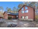 Attractive two-story home with a two-car garage and stone accents amidst a wooded backdrop at 3680 Tate Rd, Atlanta, GA 30349