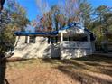 Newly renovated brick home with a covered porch and driveway, nestled amongst lush trees at 3372 Jackson Dr, Decatur, GA 30032