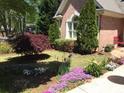 Landscaped front yard with flowering plants and shrubs at 2813 Livsey Woods Dr, Tucker, GA 30084