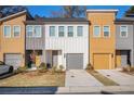 Row of townhomes featuring gray, white, and mustard exteriors, attached garages, and landscaping at 1624 Gunnin Nw Trce, Atlanta, GA 30318