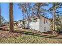 Side view of a freshly painted white brick ranch home with new landscaping at 1723 Capistrana Pl, Decatur, GA 30032