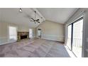 Spacious living room with a stone fireplace and carpeting at 2193 Hampton Se Trl, Conyers, GA 30013