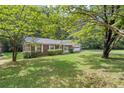 House nestled amongst lush greenery with a large yard at 2616 Landington Nw Way, Duluth, GA 30096