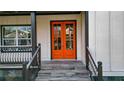 Stylish orange double front door with glass panels, leading to a porch with gray stone tile at 4562 Spring St, Acworth, GA 30101