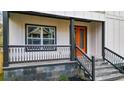 Covered porch with black metal railings and gray stone tile flooring at 4562 Spring St, Acworth, GA 30101