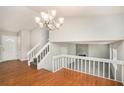 Open dining room with hardwood floors, a chandelier, and a loft view at 676 Tarkington S Rd, Stone Mountain, GA 30088