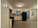 Eat-in kitchen with white cabinets and black appliances at 5423 Pine Valley Dr, Union City, GA 30291
