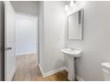 Simple powder room with pedestal sink and hardwood floors at 7065 Brushwood Bnd, Lithonia, GA 30058