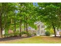 Two-story house nestled among lush green trees, showcasing a well-manicured lawn at 118 Planterra Way, Peachtree City, GA 30269