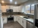 Renovated kitchen, white cabinets, granite counters, and stainless steel appliances at 1312 Buttercup Ct, Lawrenceville, GA 30044