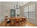 Formal dining room featuring a mid-century modern table and chairs, hardwood floors, and large windows at 260 Wildcat Lake Dr, Lawrenceville, GA 30043