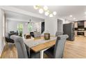 Modern dining room with a wood table and gray chairs, open to the living area at 126 Marona Ne St, Atlanta, GA 30307