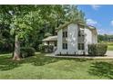 White brick house with a large tree in front and green lawn at 5132 Kurt Sw Ln, Conyers, GA 30094