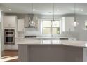 Modern kitchen featuring white cabinets, large island, and stainless steel appliances at 5203 Morrell Rd, Hoschton, GA 30548