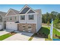 Two-story townhome with gray and beige siding, brick accents, and a two-car garage at 318 Crimson Dr, Union City, GA 30291
